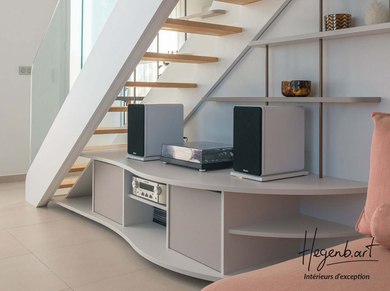 Transformation d'un escalier par un garde-corps en verre, des étagères décoratives et un meuble hifi sous escalier Image